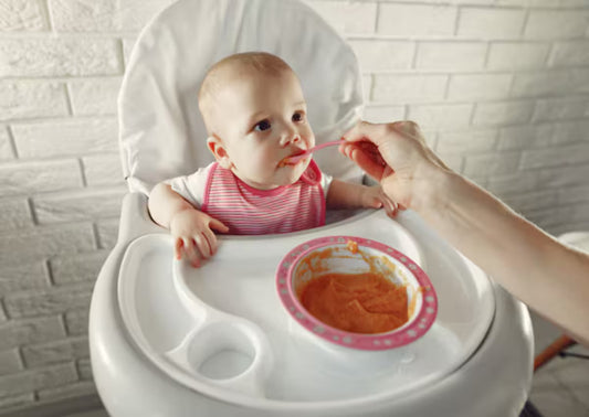 A mother feeding her baby some sea moss mixed in food